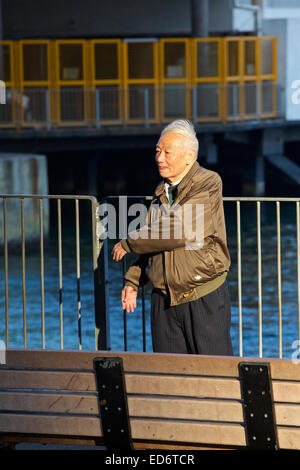 Elderly Chinese Man Preforming His Morning Tai Chi On The North Point Waterfront In Hong Kong. Stock Photo