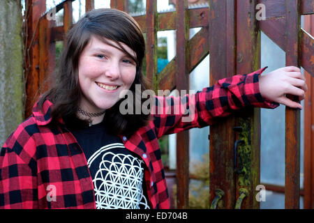 twelve year old smiling girl posing for a portrait in family garden Stock Photo