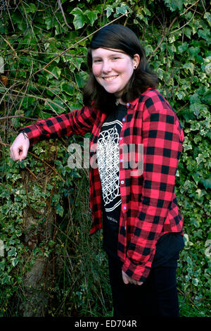 twelve year old smiling girl posing for a portrait in family garden Stock Photo