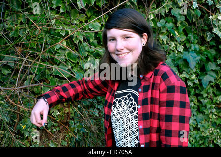 twelve year old smiling girl posing for a portrait in family garden Stock Photo