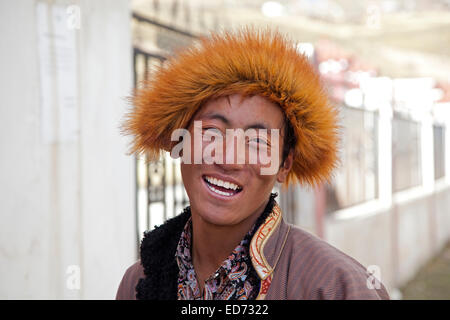 Close up portrait of smiling Tibetan man with fur hat in the village Qagca / Cacagoin, Sichuan Province, China Stock Photo