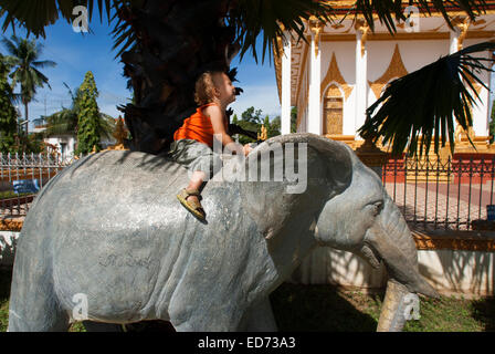 Girls uploaded an elephant statue in Wat Kampheng Temple. Battambang. Cambodia. Travel with children’s. Wat Kampheng Just behind Stock Photo