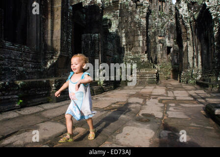 Girl walking alone in Bayon temple. Angkor Thom. Angkor Thom was built as a square, the sides of which run exactly north to sout