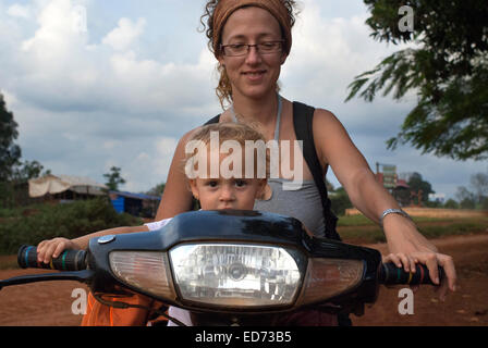 Travel with children’s. Mother riding a motorbike with her daughter. Ratanakiri. The protected area of Yeak Lom includes a circu Stock Photo