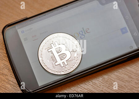 bitcoin virtual currency coin on a smartphone Stock Photo
