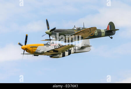 RAF Spitfire and USAF P51 Mustang world war two historic fighters flying in formation Stock Photo