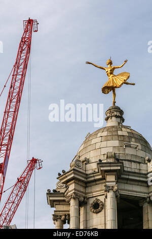 Cranes above the roof of the Victoria Palace theatre in London.  The gilded statue of Anna Pavlova sits on top of the dome. Stock Photo