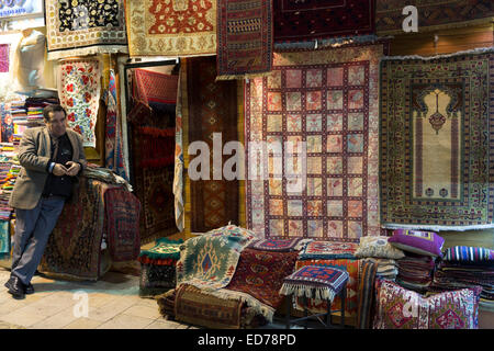 Salesman at Turkish carpet rug shop in The Grand Bazaar, Kapalicarsi, great market in Beyazi, Istanbul, Turkey Stock Photo