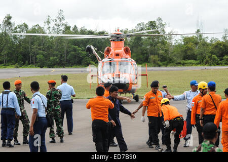 Pangkalan Bun, Indonesia. 31st Dec, 2014. People gather around a helicopter that brings back bodies of victims on AirAsia flight QZ8501 at Iskandar Air Base, in Pangkalan Bun, Central Kalimantan, Indonesia, Dec. 31, 2014. Indonesian rescuers searching for the missing AirAsia plane have spotted six bodies and recovered three from waters off the southern coast of Kalimantan island, shortly after they observed floating debris later confirmed to be from the ill-fated plane. Credit:  Veri Sanovri/Xinhua/Alamy Live News Stock Photo