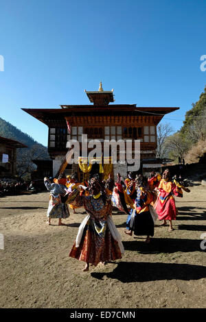 Masked dancers taking part in a rare and old sacred dance called Zhey not performed elsewhere in Bhutan during the annual religious Bhutanese Tshechu festival in Ngang Lhakhang a Buddhist monastery also known as the 'Swan temple' built in the 16th century by a Tibetan lama named Namkha Samdrip in the Choekhor Valley of Bumthang District central Bhutan Stock Photo