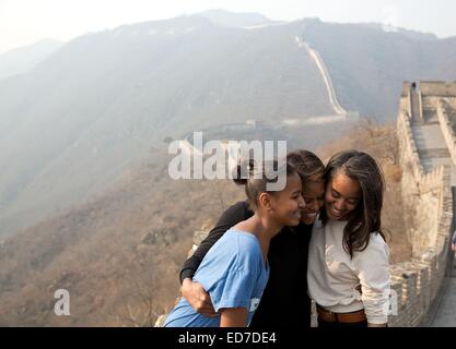 US First Lady Michelle Obama hugs daughters Sasha and Malia during their visit to the Great Wall of China March 23, 2014 in Mutianyu, China. Stock Photo