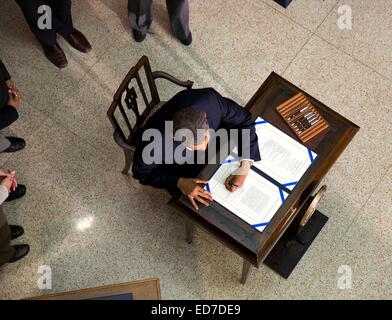 US President Barack Obama signs H.R. 3547, the Consolidated Appropriations Act, 2014, funding the government for fiscal year 2014 during a ceremony in the New Executive Office Building January 17, 2014 in Washington, DC. Stock Photo