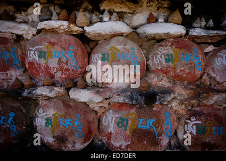 'Om mani padme' Tibetan mantra inscription on stone in front of the Buddhist Kurjey Lhakhang monastery which consists of three large temples surrounded by a perimeter of 108 stupas located in the Bumthang valley in the Bumthang district of Bhutan Stock Photo