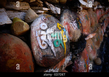 'Om mani padme' Tibetan mantra inscription on stone in front of the Buddhist Kurjey Lhakhang monastery which consists of three large temples surrounded by a perimeter of 108 stupas located in the Bumthang valley in the Bumthang district of Bhutan Stock Photo