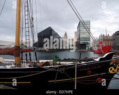 Old ship docked in Liverpool with the Liver building in the background and new apartment buildings. Stock Photo