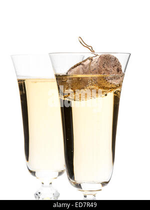 Closeup of two champagne glasses with champagne cork floating in one glass shot on white Stock Photo