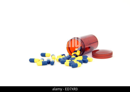 isolated capsules spilling out from small bottle Stock Photo