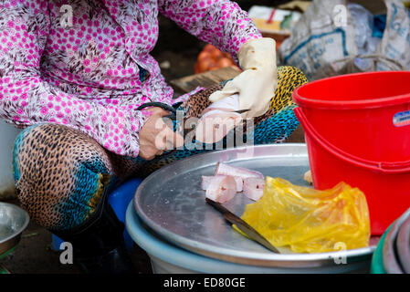 Woman preparing fish at street market in Saigon Stock Photo