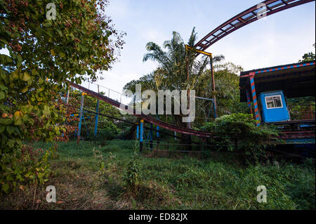 Rusty decayed roller coaster tracks at Yangon abandoned amusement park Stock Photo