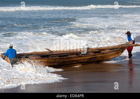 Fishermen launching a boat at Prampram, Greater Accra, Ghana, Africa Stock Photo