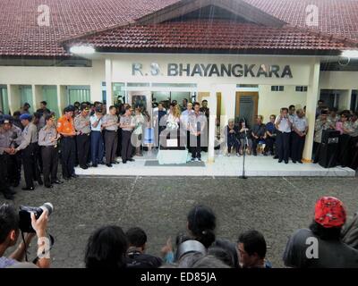 (150101) -- SURABAJA, Jan. 1, 2015 (Xinhua) -- People stand in silent tribute after the first body of crashed AirAsia plane victims arrives at the Bhayangkara hospital in Surabaja, on Jan. 1, 2015. Experts identifying victims of the AirAsia plane that sank in Indonesia's water announced the first result of their works to identify two bodies on Thursday, saying they were to hand one of them to her family soon. Head of Disaster Victim Identification (DVI) named only Budiono said that one of the two bodies was successfully identified to be an Indonesian woman named Hayati Lutfiah Hamid from East Stock Photo