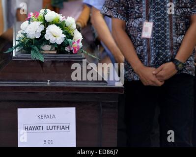 Surabaya. 1st Jan, 2015. People stand in silent tribute during the hand over ceremony in Surabaya, on Jan. 1, 2015. Experts identifying victims of the AirAsia plane that sank in Indonesia's water announced the first result of their works to identify two bodies on Thursday, saying they were to hand one of them to her family soon. Head of Disaster Victim Identification (DVI) named only Budiono said that one of the two bodies was successfully identified to be an Indonesian woman named Hayati Lutfiah Hamid from East Java province. Credit:  He Changshan/Xinhua/Alamy Live News Stock Photo