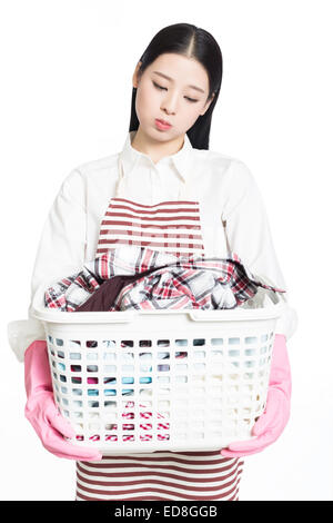 young woman holding a basket of folded laundry. white background. Stock Photo