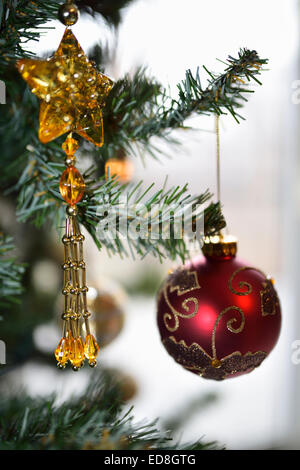Red and gold ornaments hanging from a Christmas tree Stock Photo