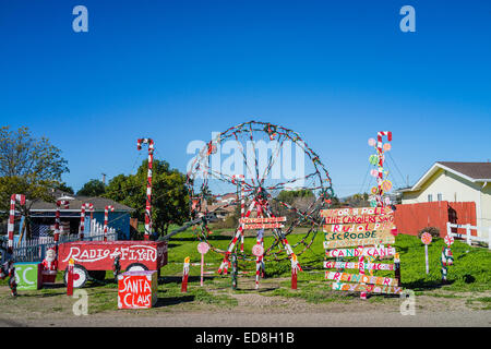 Bizarre Christmas display with a colorful homemade over-sized Radio Flyer wagon, small scale ferris wheel, and large candy canes Stock Photo