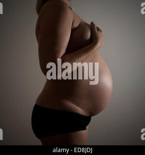 Side shot of heavily pregnant woman at 37 weeks gestation Stock Photo