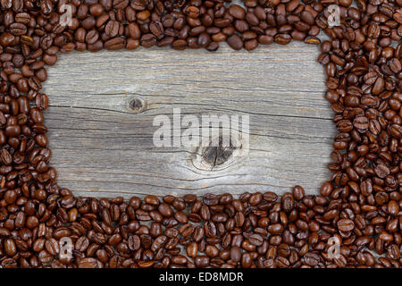 Close up of freshly roasted coffee whole beans, forming a rectangle shape, on rustic naturally aged wood Stock Photo