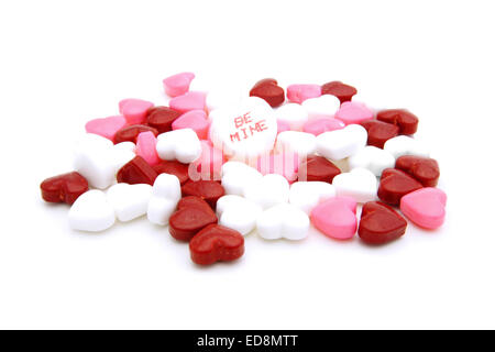 Pile of Valentines Day heart-shaped candies with 'Be Mine' conversation heart Stock Photo