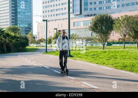 Young man on an Electric kick scooter on a bicycle path. Photographed in Ramat HaHayal, Tel Aviv, Israel Stock Photo