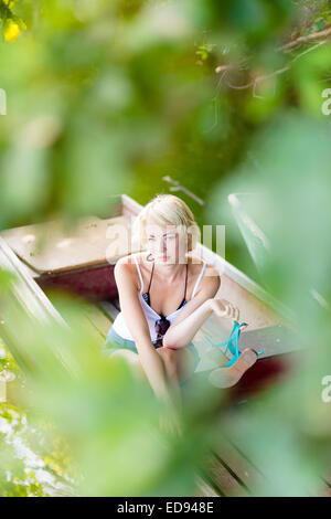 Woman relaxing on the vintage wooden boat. Stock Photo