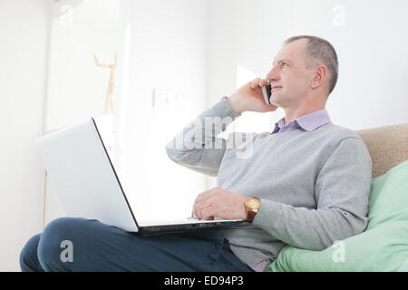 Adult man calling by smartphone at home Stock Photo