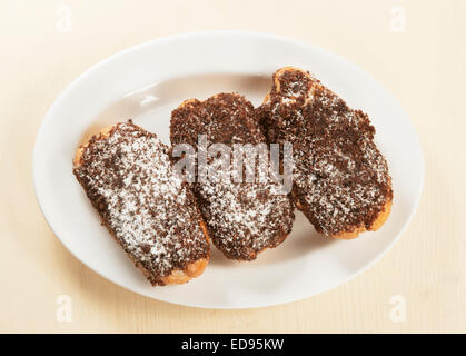 Eclairs with chocolate chips on a plate Stock Photo
