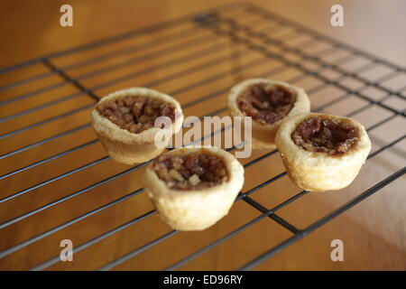mini pecan tarts on a  black cooling rack Stock Photo