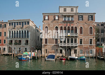 Substantial palace buildings houses palazzo pallazi with moored motor boats on the Grand Canal Venice Italy Stock Photo