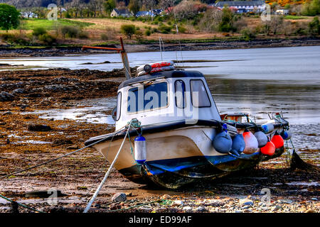 The tide is out and this small fishing boat has done it's days work at Broadford on the Isle of Skye, Scotland Stock Photo