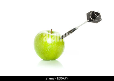 Green apple as a target for black steel dart, closeup photo on white background Stock Photo