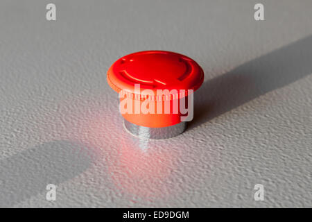 Red emergency stop switch reset industrial button on gray steel panel Stock Photo