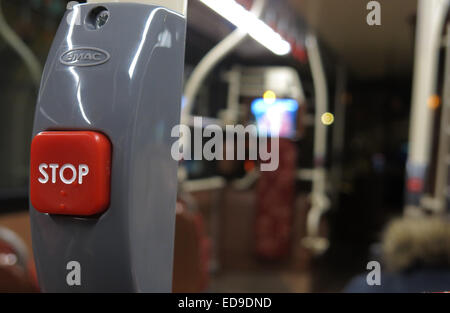 Red Stop button on a public bus, Lothian Scotland, out of focus (with Braille ) at night Stock Photo