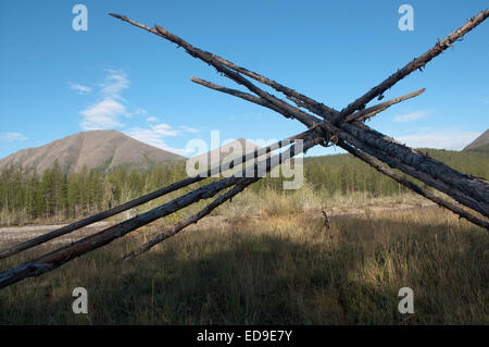 Russia, Yakutia. Poles of an abandoned camp on the Bank of mountain river. Stock Photo