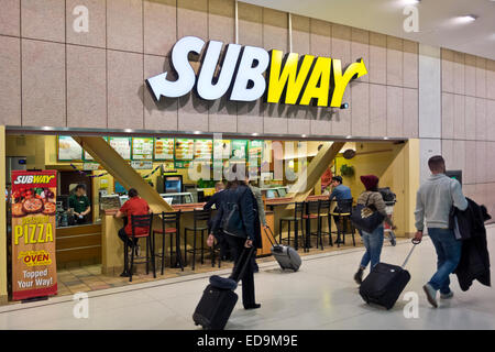 Air travelers with suitcases pass by a Subway sandwich restaurant at Toronto Airport, Canada.  Fast food meals. Stock Photo