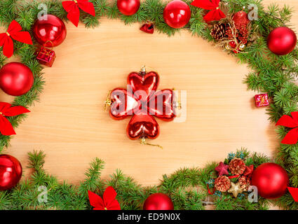 Christmas or New Year decoration with pine or fir and red ornaments balls on wooden texture with four hearts in middle.  Empty s Stock Photo