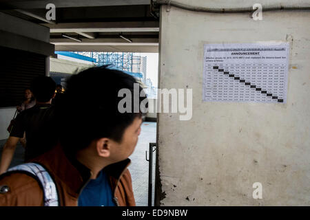 An MRT passenger looks at the new fare matrix that will be implemented on Jan. 4, 2015. © Mark Z. Saludes/Pacific Press/Alamy Live News Stock Photo