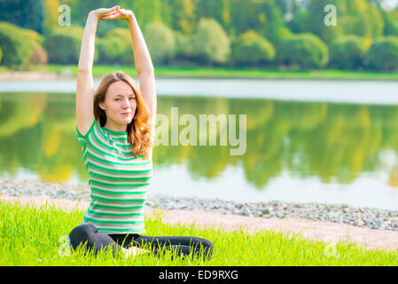red-haired young girl goes in for sports near the lake Stock Photo