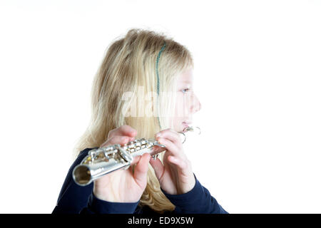 young blond girl playing flute in studio against white background Stock Photo