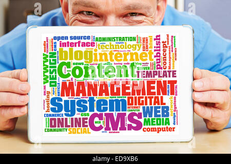 Business man holding tablet PC with CMS tag cloud on the screen Stock Photo