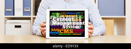 Tablet computer with CMS concept being held by female hands on office desk Stock Photo